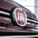 man taking photo of fiat emblem