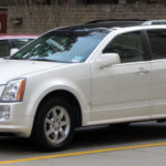 guy driving down the road with his cadillac srx