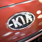 closeup of kia logo on car hood