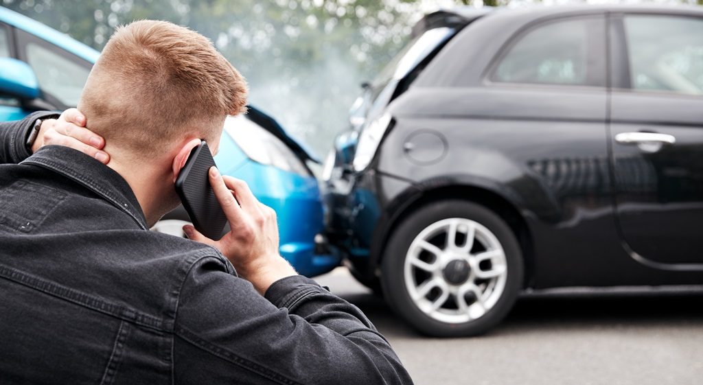 man calling the police after car accident