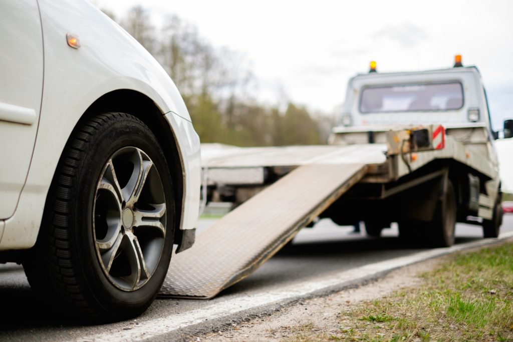 car towed by a truck because of power steering failure