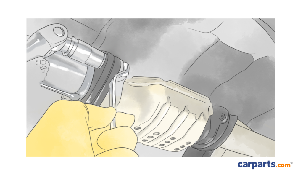 using a wrench to remove an old catalytic converter from other exhaust parts