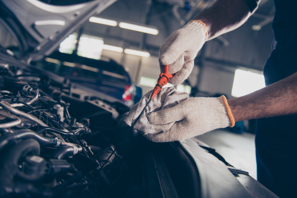 mechanic checking fluid dipstick