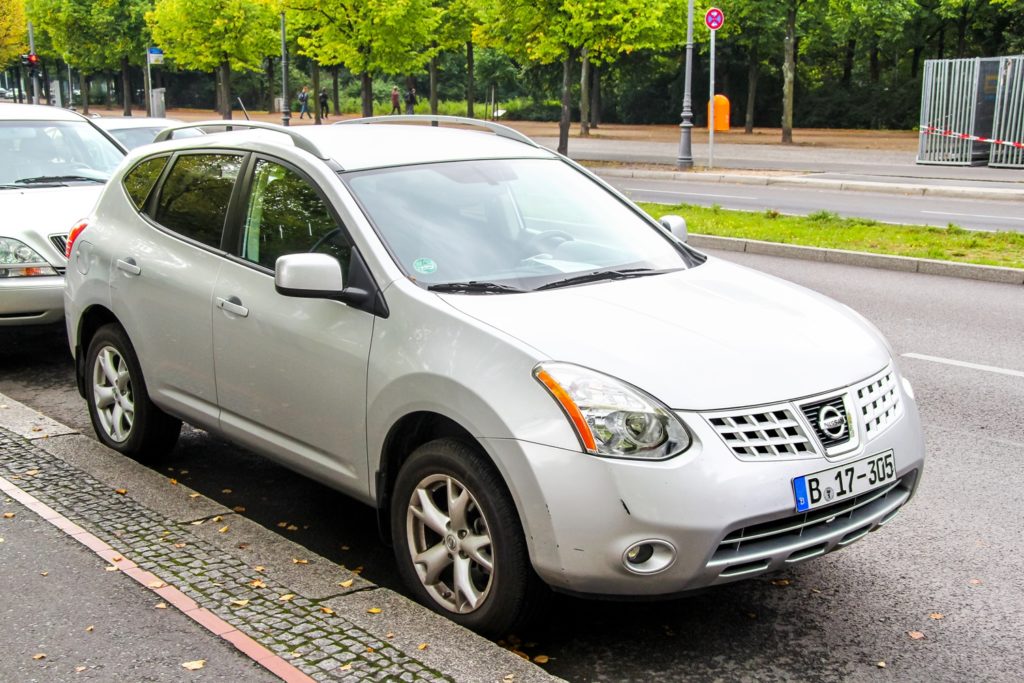 White Nissan Rogue parked by the street