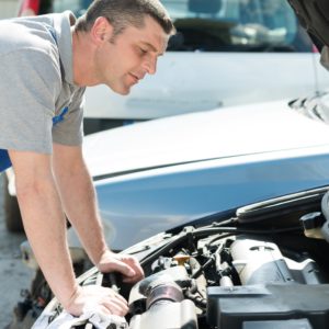 mechanic diagnosing car with hood open