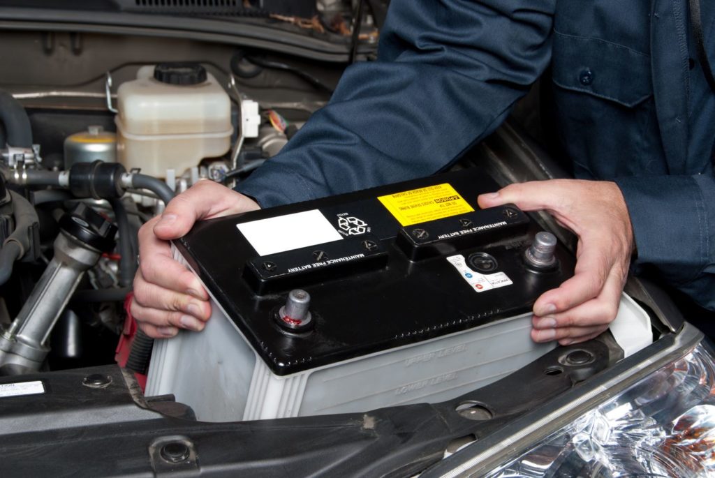 mechanic replacing drained car battery