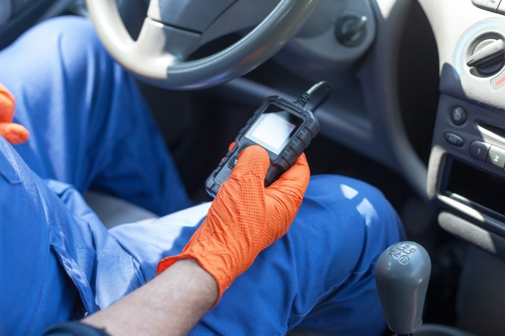 auto mechanic using car diagnostic scan tool