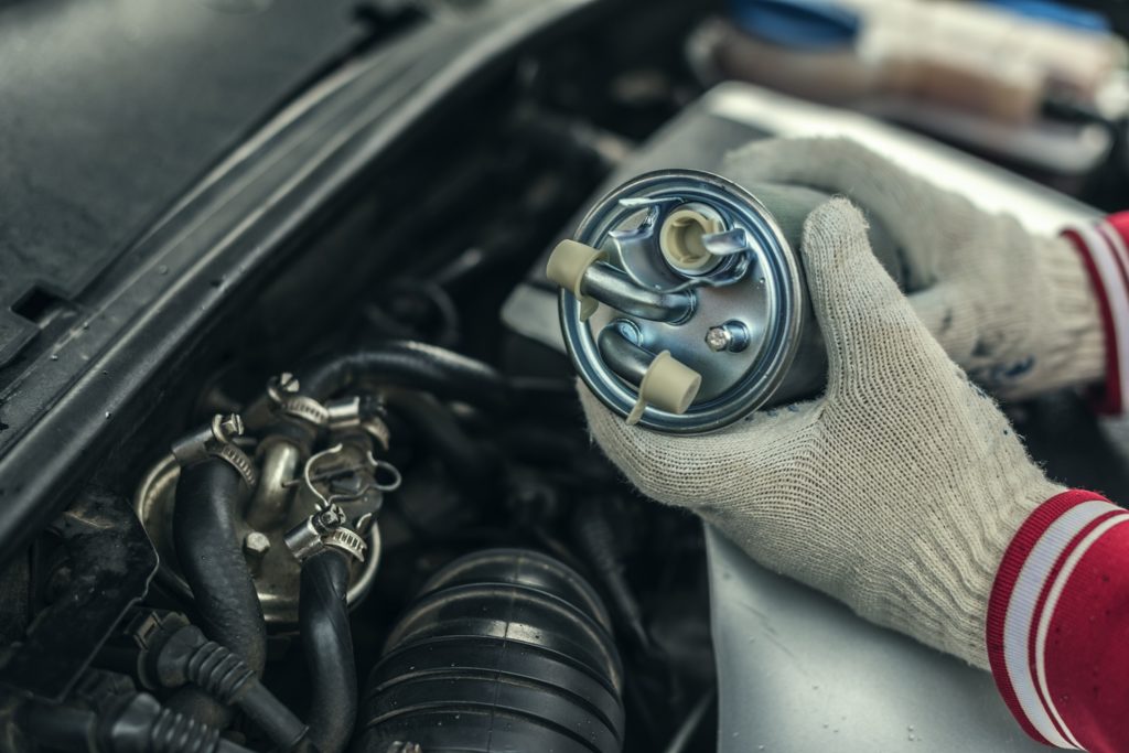mechanic replaces car fuel filter