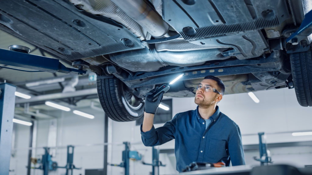 mechanic checking vehicle chassis