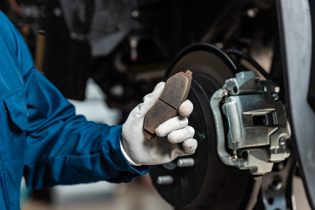 mechanic holding a brake pad
