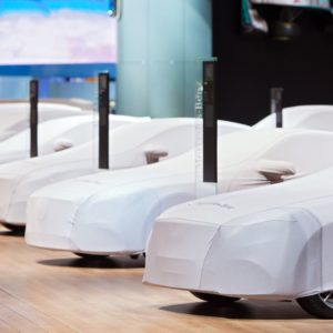 a row of covered cars in auto show