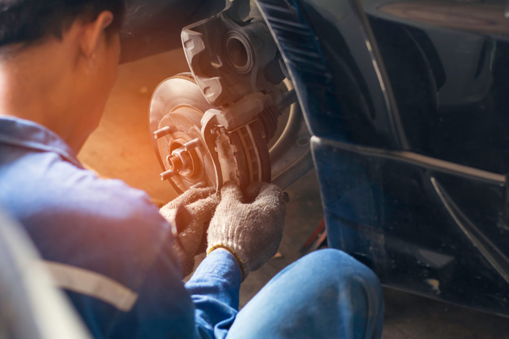 mechanic checking brake disc during repair