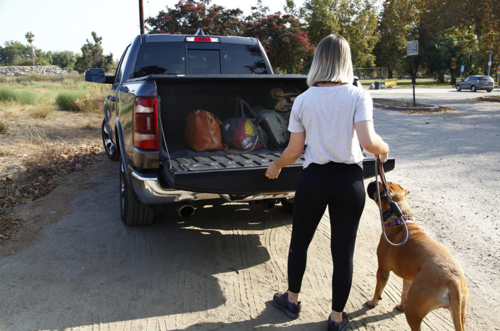 woman with dog checking truck with tonneau cover