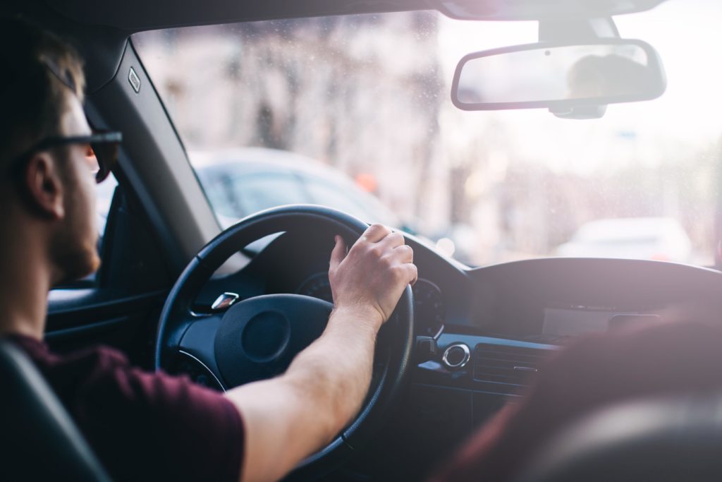 Man driving at daytime around the city