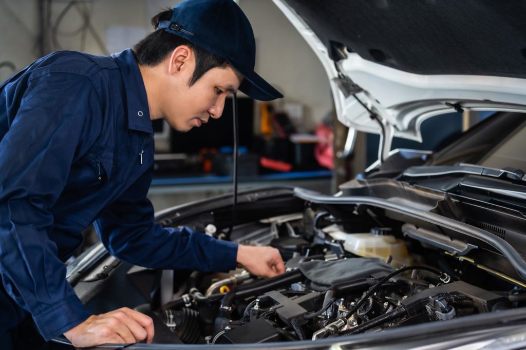 mechanic checking on car hood