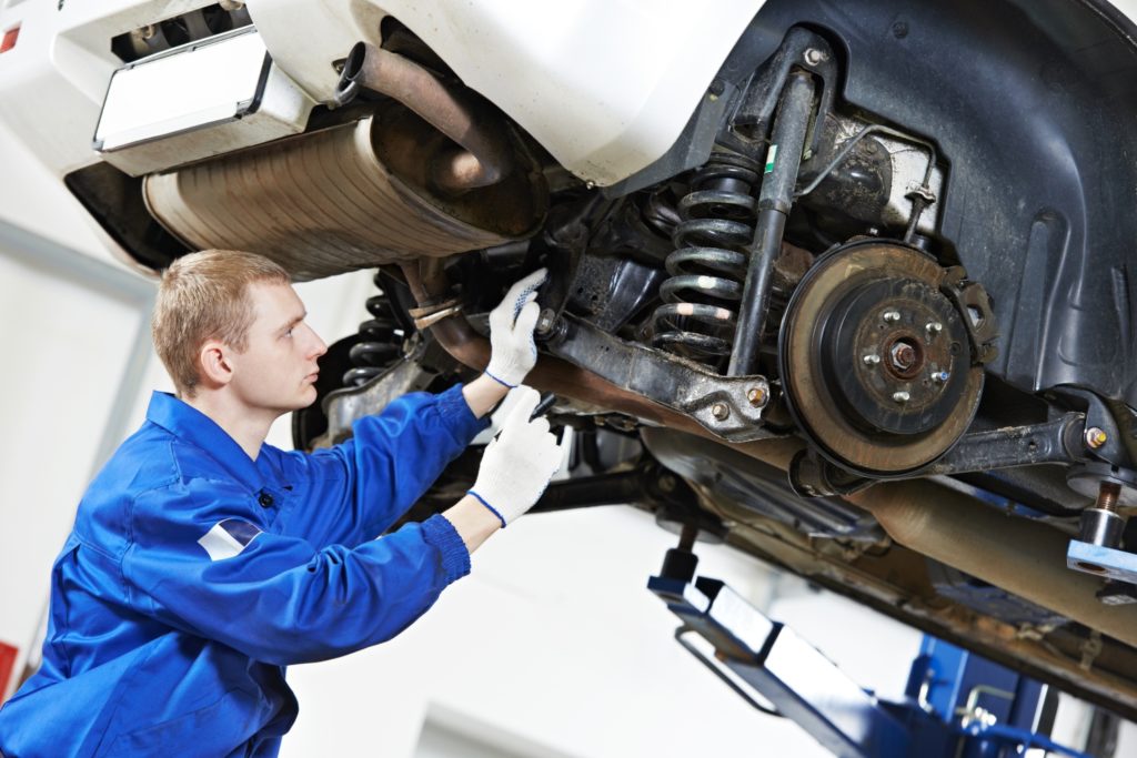 mechanic checking front suspension
