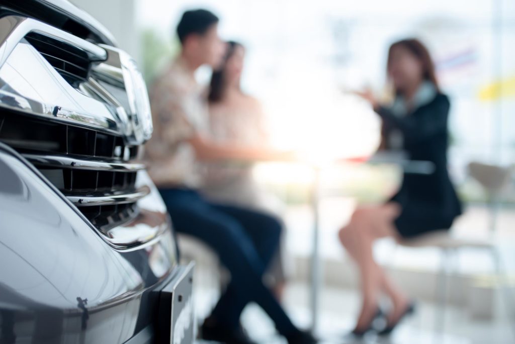 dealership talking to people interested in buying a car