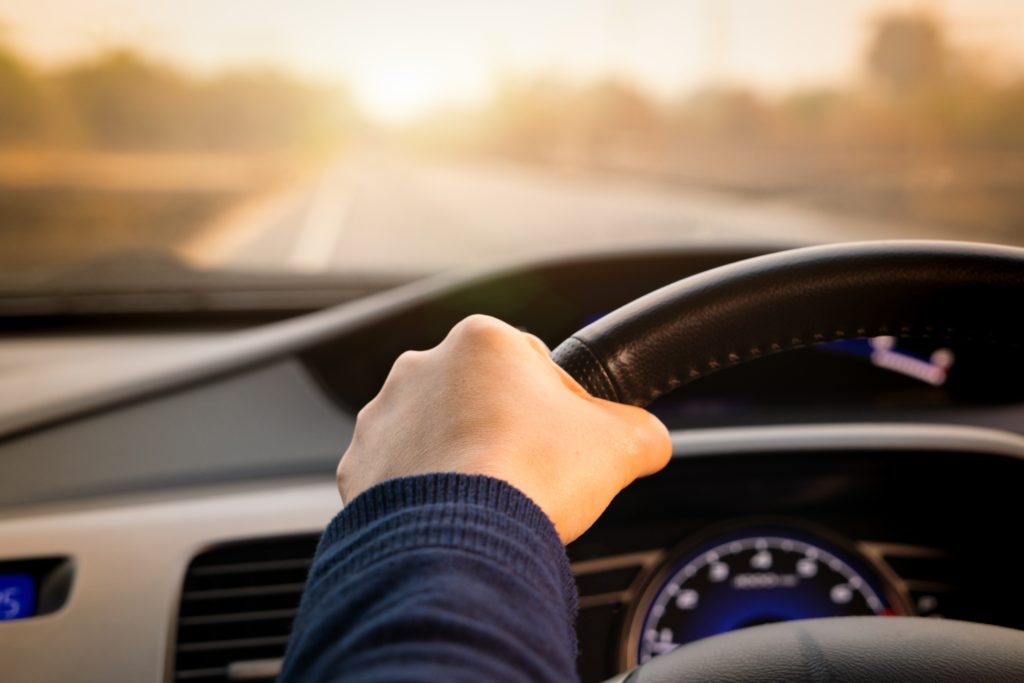 hand holding a steering wheel