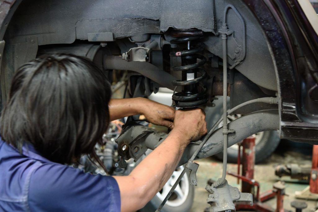 technician changing car shock absorber