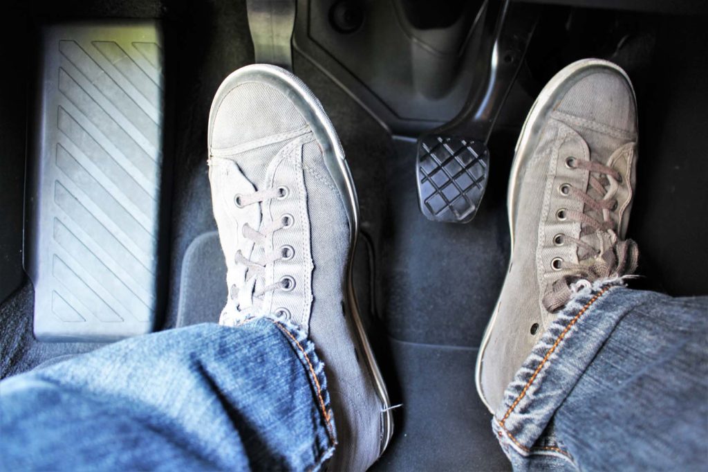 driver feet on clutch pedal and accelerator