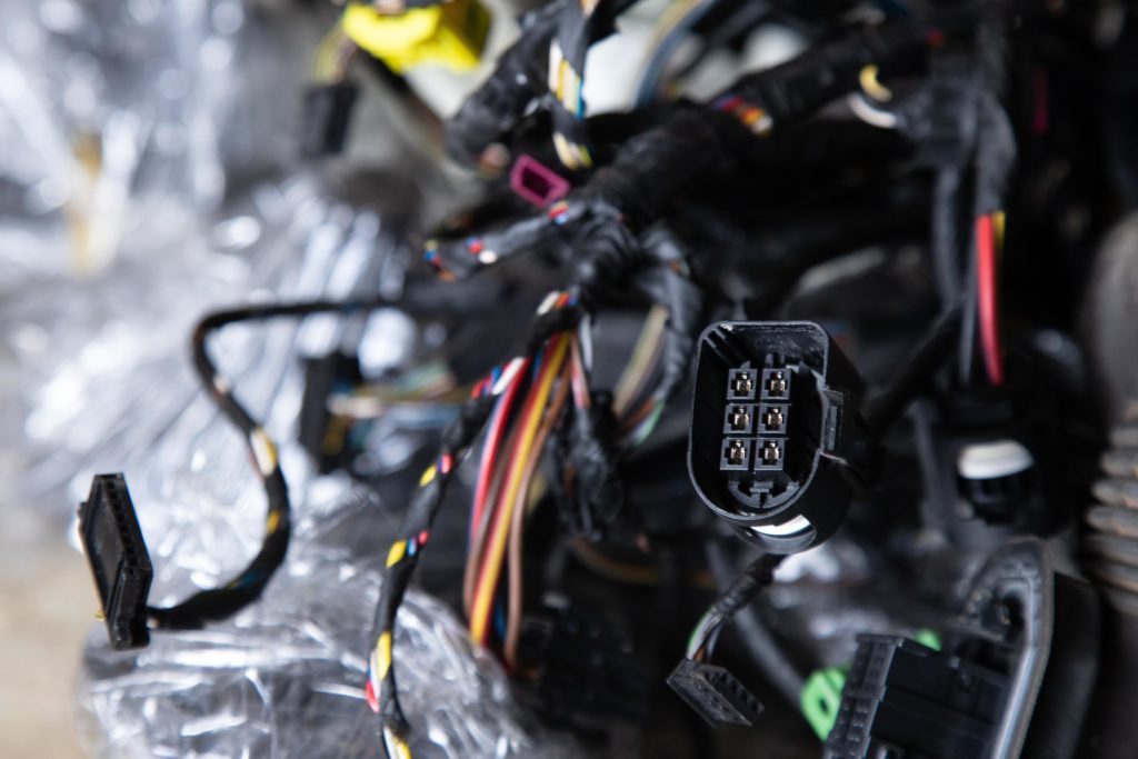 engine control unit or ECU of a car with multicolored wires plug at foreground