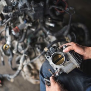 mechanic holding electronic throttle body