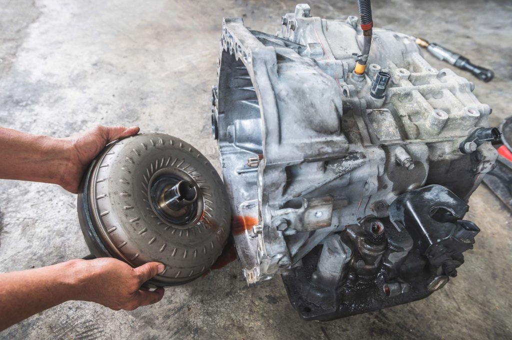 car mechanic taking the torque converter from the automatic transmission