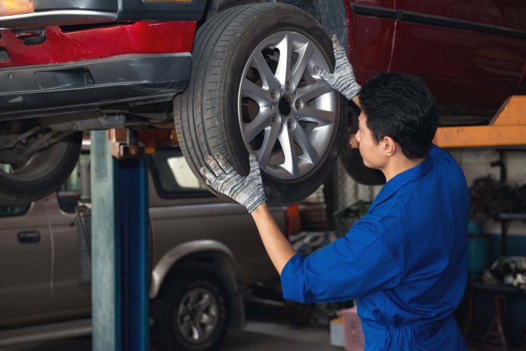 mechanic installs car wheel