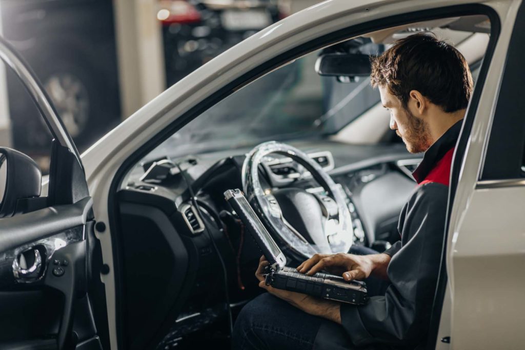 male mechanic using special tools to do diagnostics