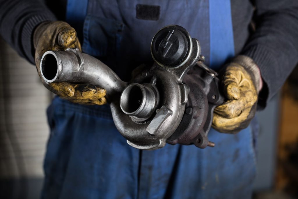mechanic holding a car turbocharger