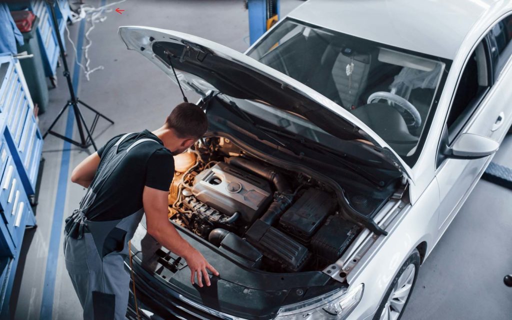 car hood open with man inspecting engine after detecting P0621