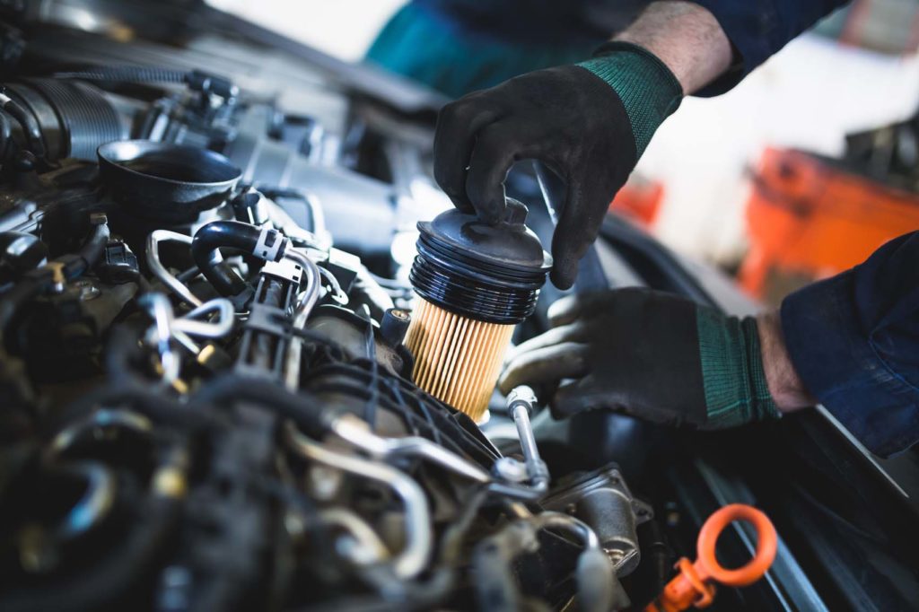 car mechanic doing oil and fuel filter changing
