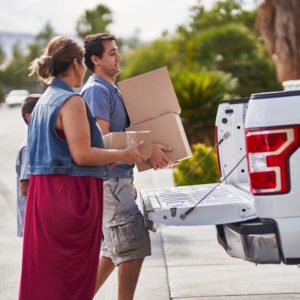 man placing packages on a pickup truck