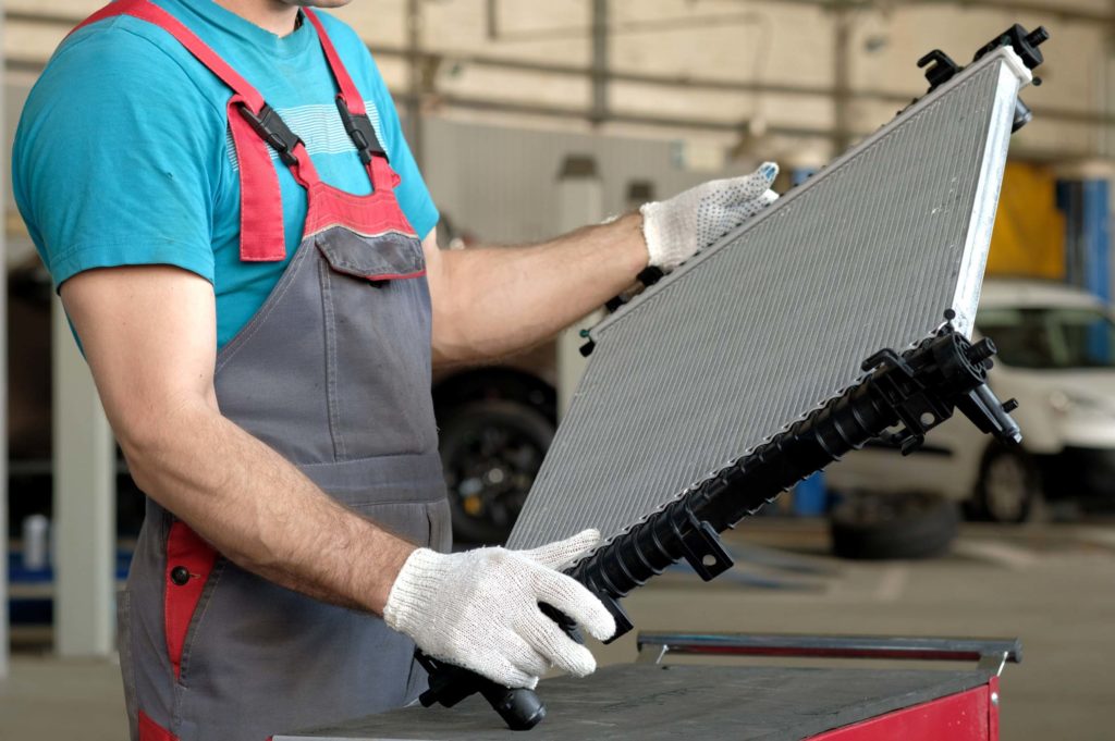 mechanic holding a new radiator