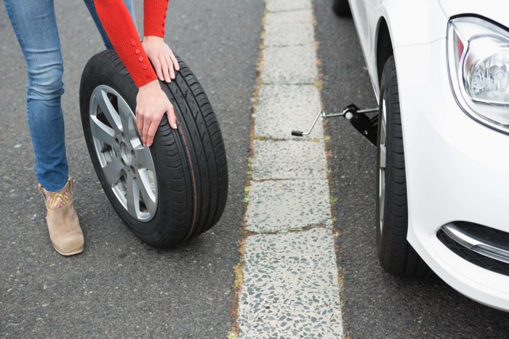 woman replacing car tire