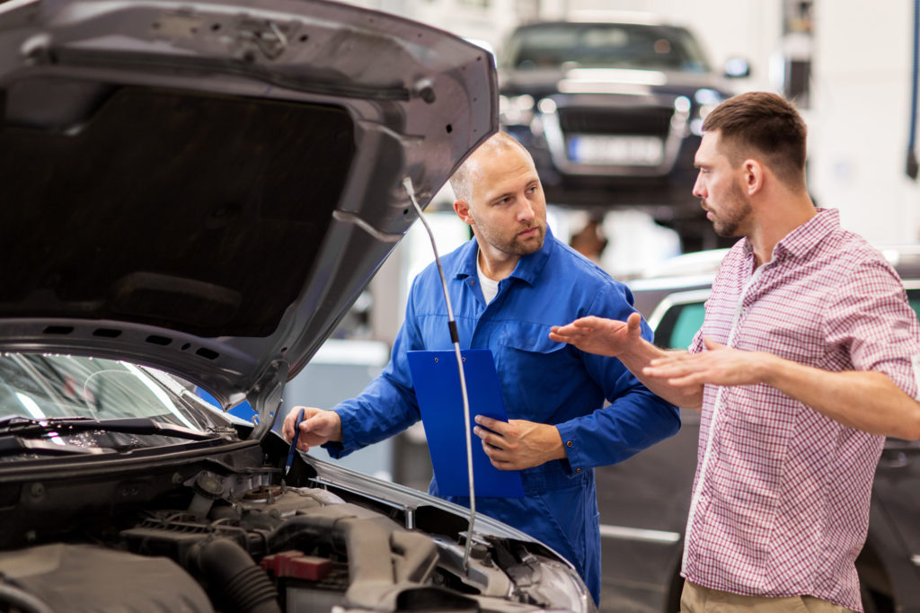 car owner explains issue to male mechanic