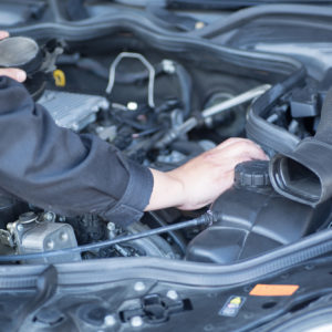mechanic checks engine area hood open