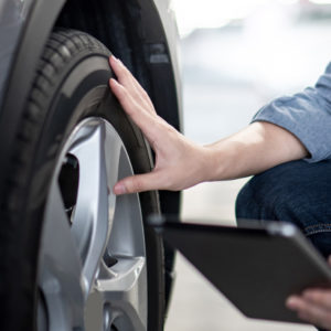 mechanic checks tire to find sensor