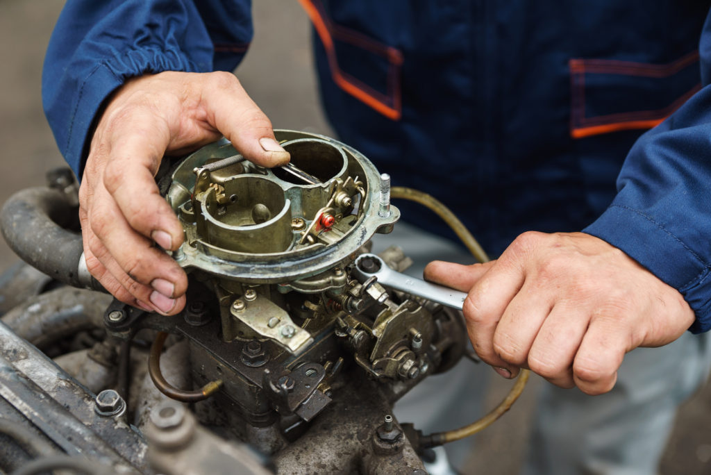 carburetor being repaired by mechanic