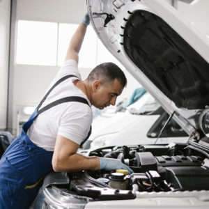 mechanic checks engine temperature under hood