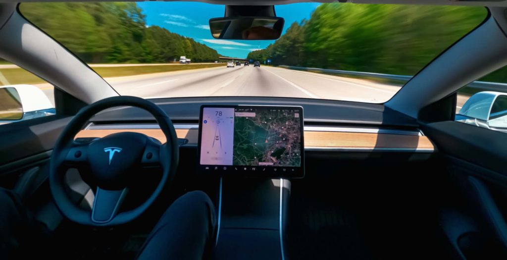 tesla car travelling on road
