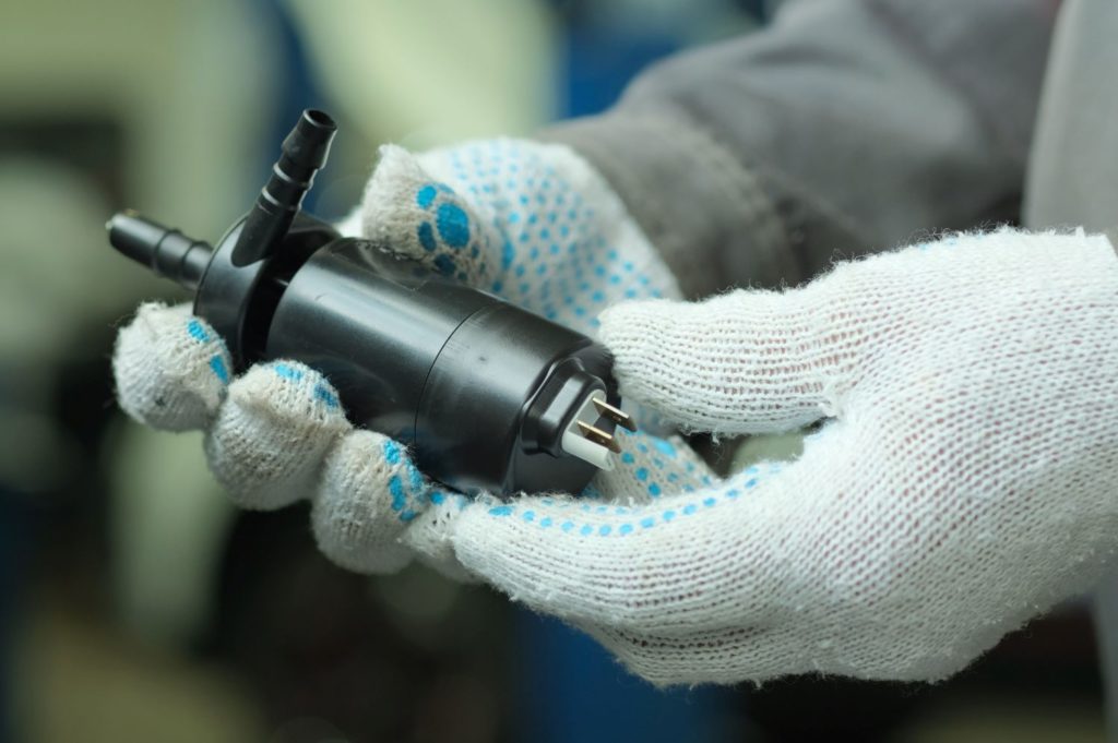 hands holding a windshield washer pump