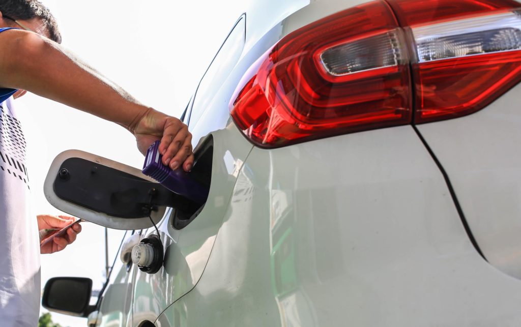 fuel additive being poured inside car gas tank