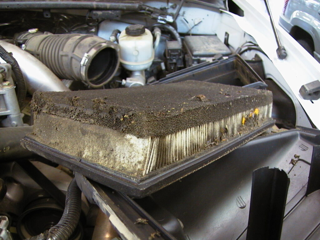 dirty engine air filter on top of car hood