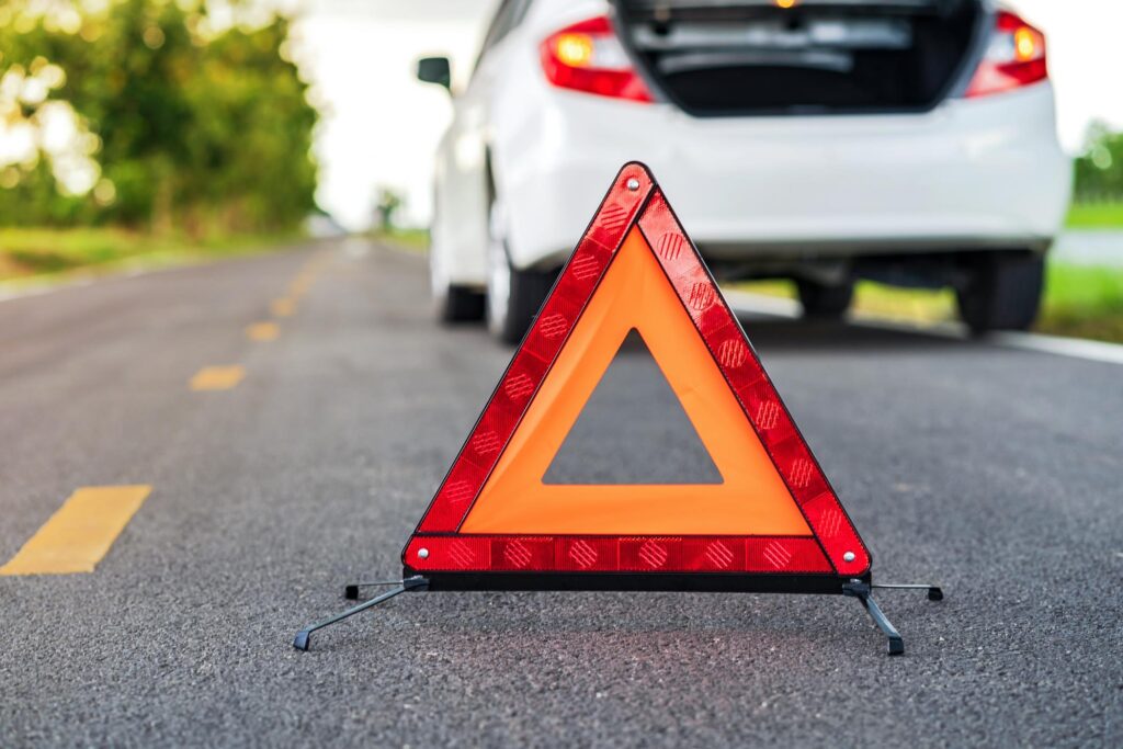 reflective triangle set up with white car in background