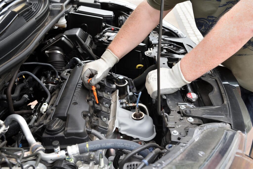 mechanic checking engine oil of a honda car