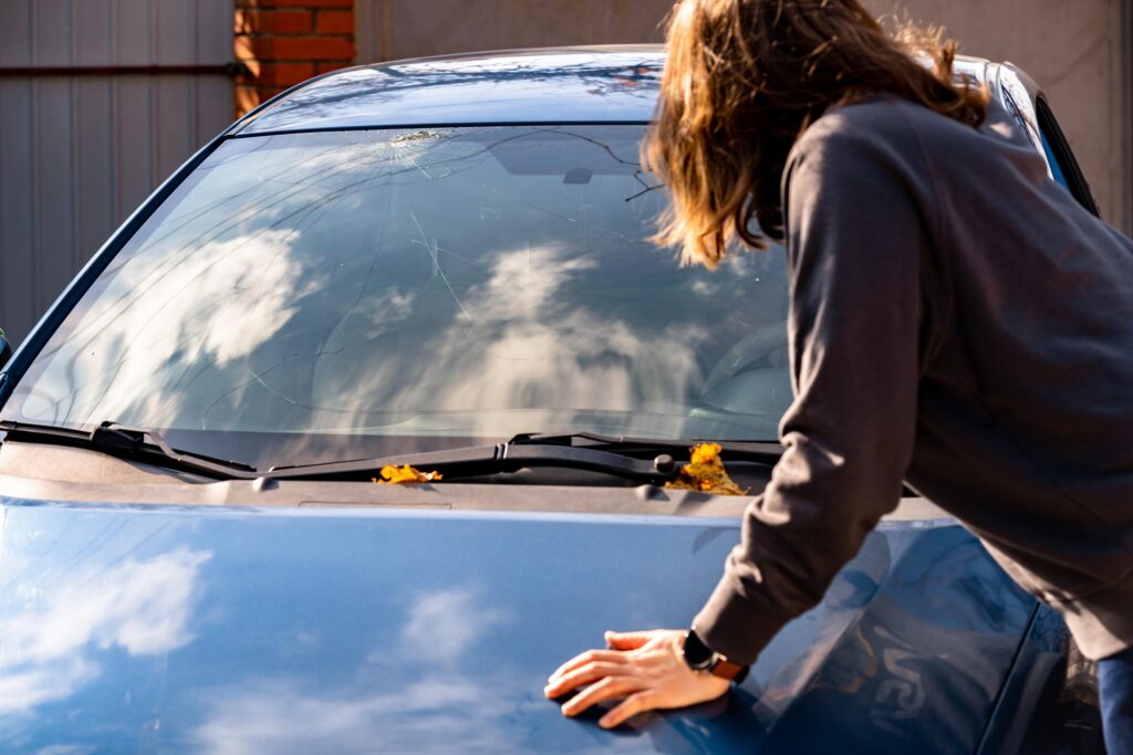 driver inspecting crack on car windshield