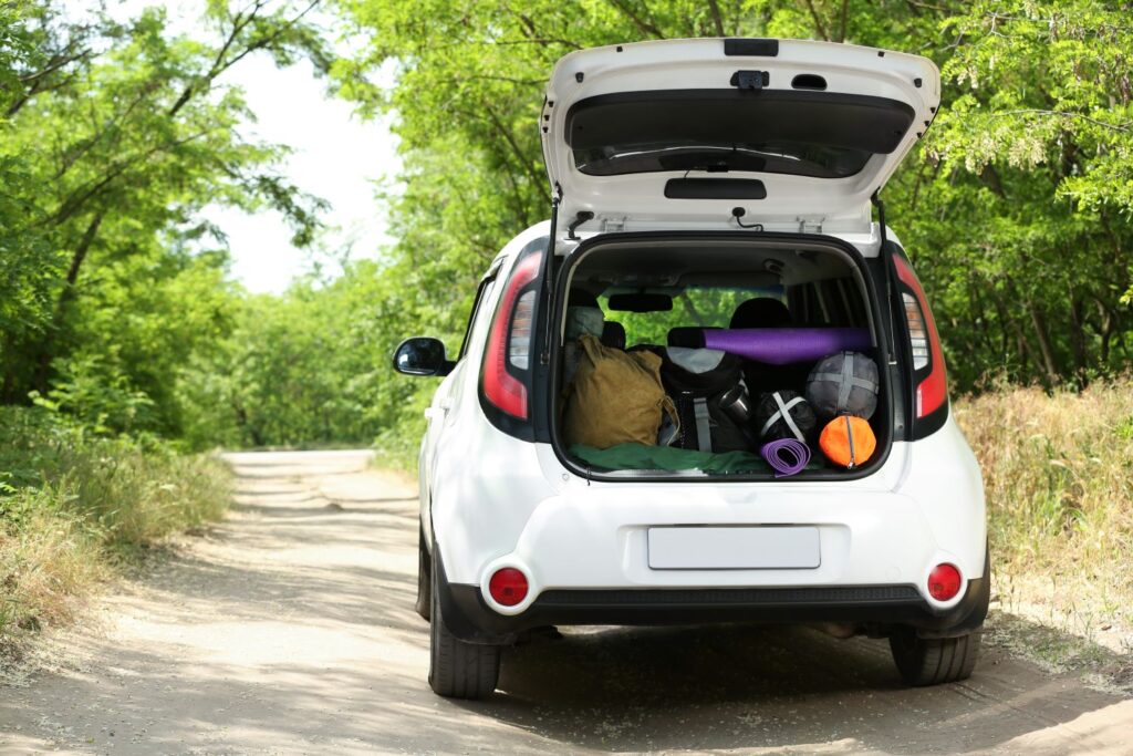 white car with an open trunk full of cargo