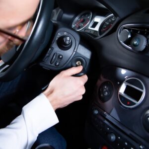 driver putting car ignition key into the ignition switch