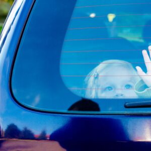 kid inside a car touching rear windshield